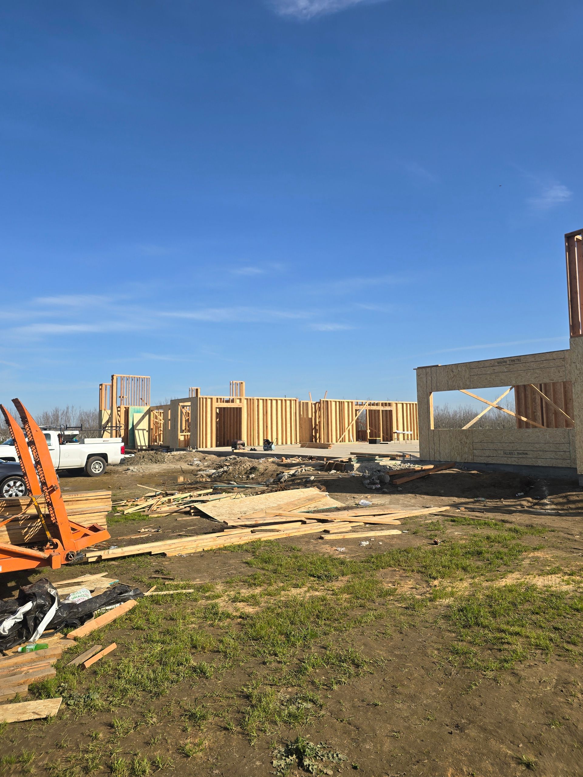 Construction site with wooden framing, debris, and a blue sky after demolition