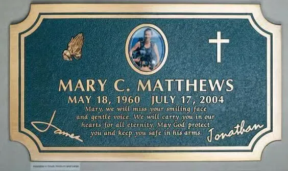 Teal memorial plaque with gold border, cross, photo, and name Mary C. Matthews, dates May 18, 1960–July 17, 2004