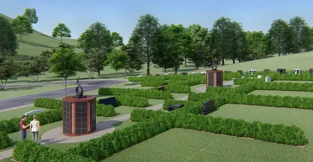 Manicured garden with hedges, trees, and brick water fountains beside a paved path