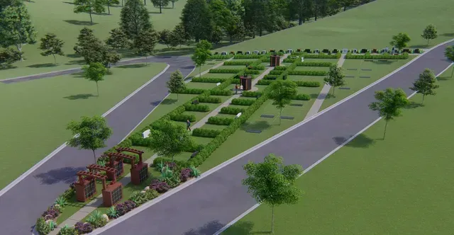Aerial view of a landscaped park with geometric garden beds, paths, and purple-arched structures beside roads.