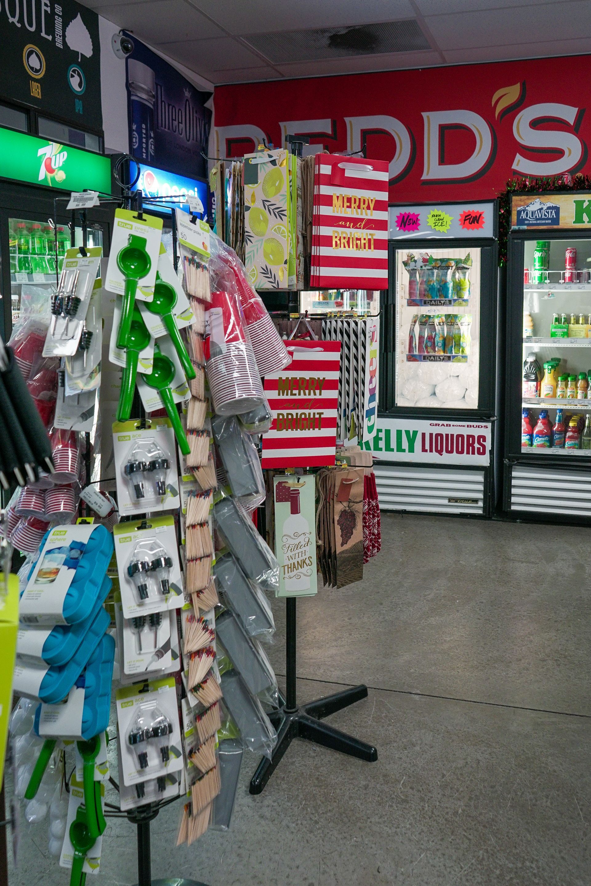 Convenience store interior with product displays, featuring gift bags, tools, and a