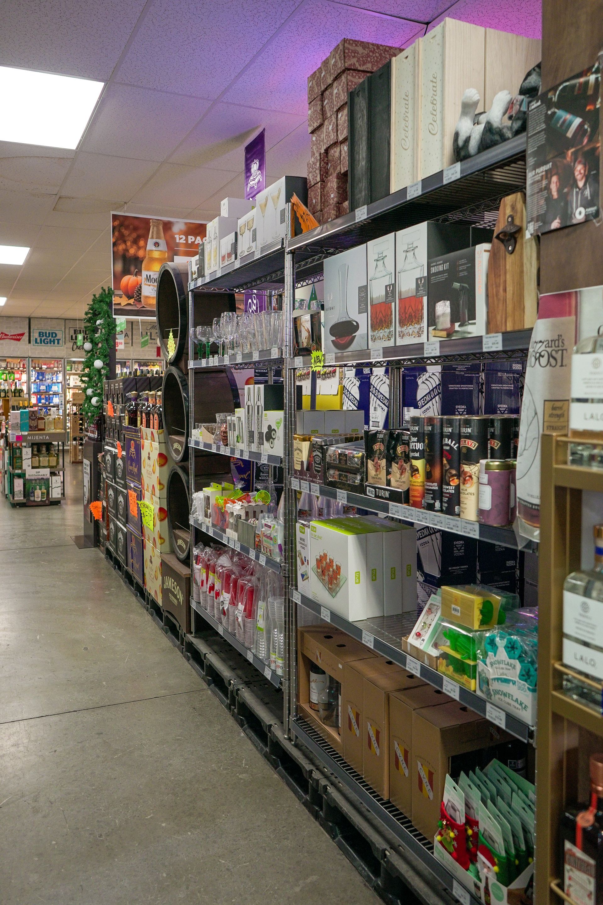 Shelves stocked with various products in a store; products include beverages, gift boxes, and other items.