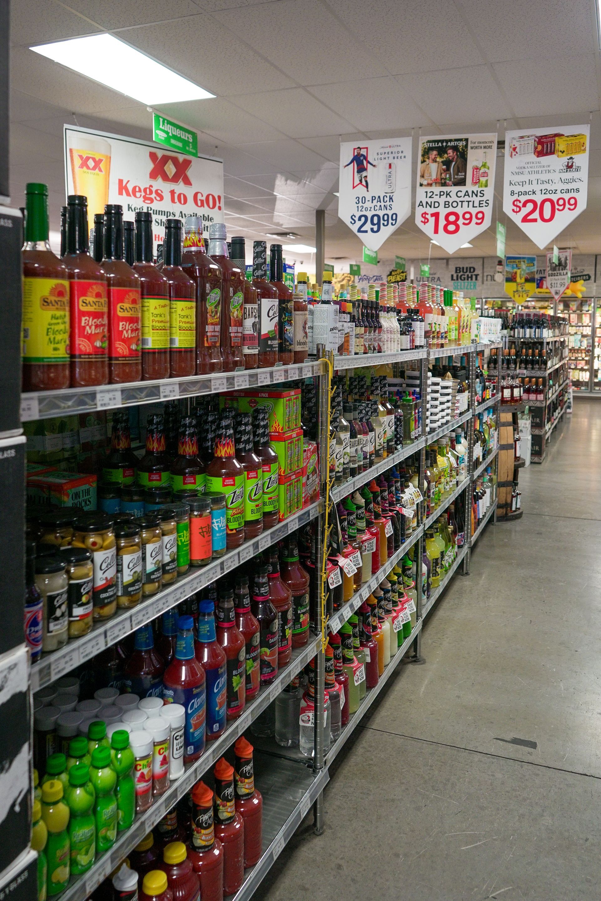 Rows of shelves stocked with various bottles and jars in a grocery store.