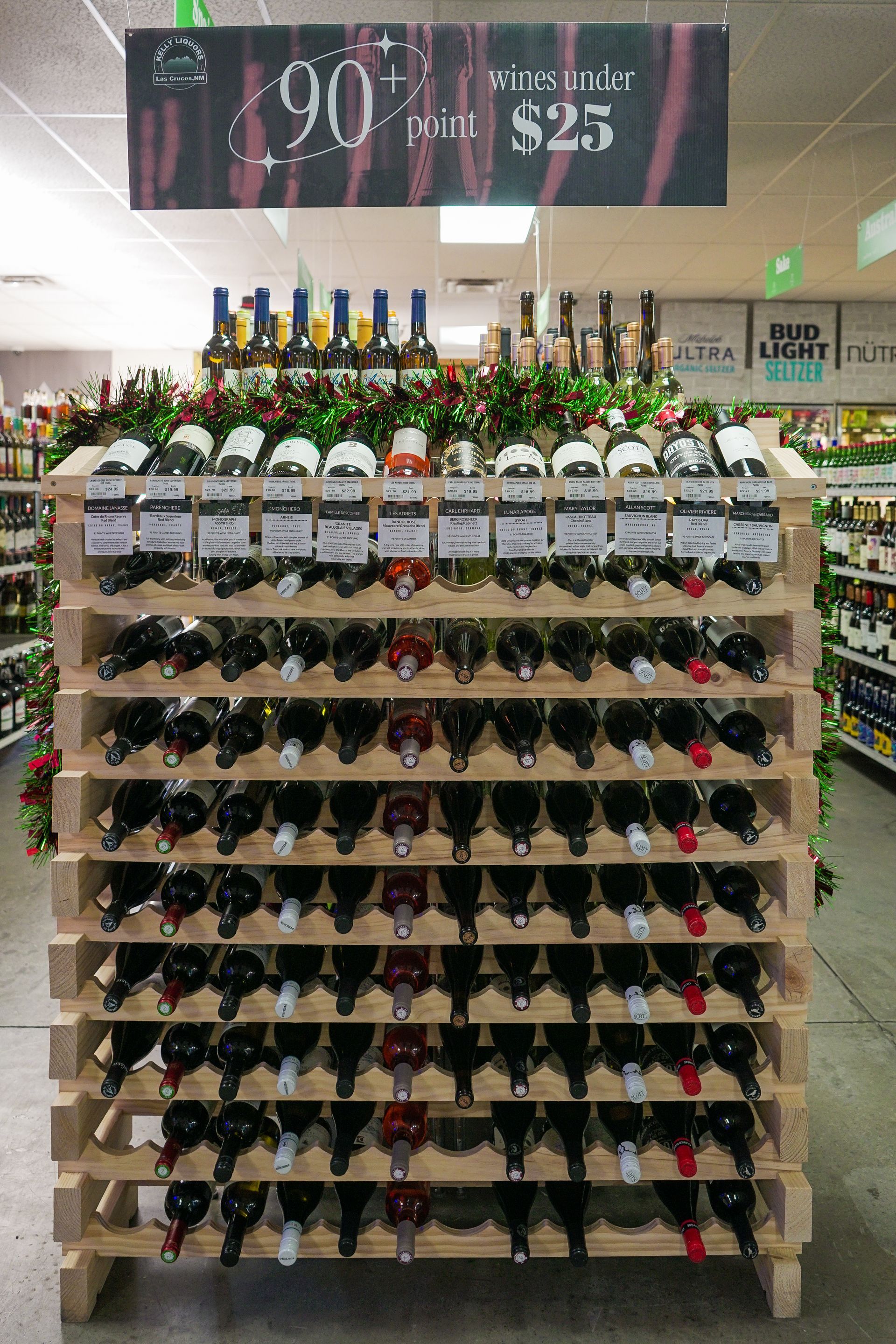 Wine display with bottles, a sign saying 90+ points for $25.