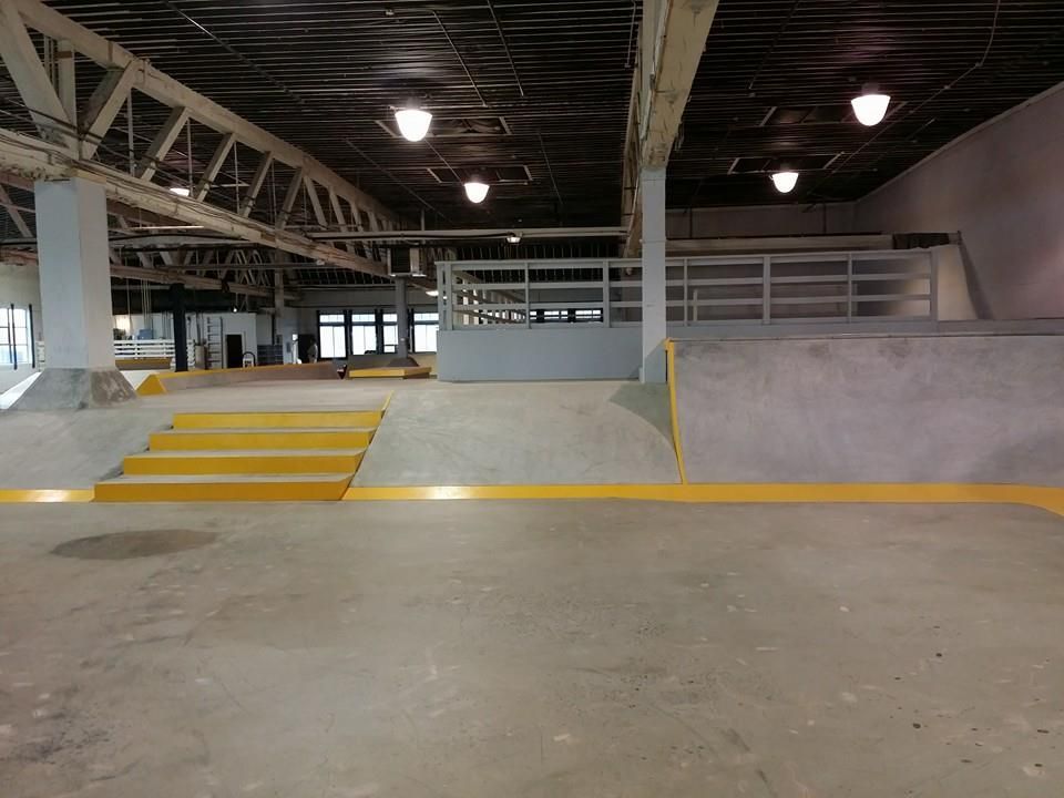 A large empty building with stairs leading up to a ramp.