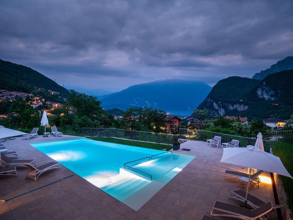 A Large Swimming Pool is Lit Up at Night With Mountains in the Background — Lismore Poolscene in Casino, NSW