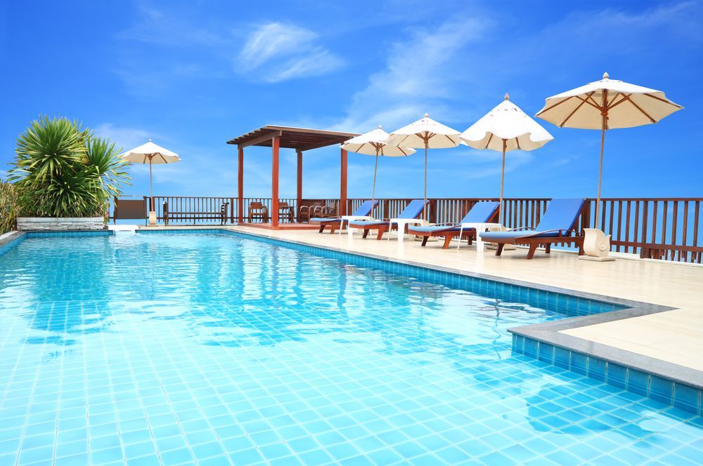 A Large Swimming Pool Surrounded by Chairs and Umbrellas — Lismore Poolscene in Eltham, NSW