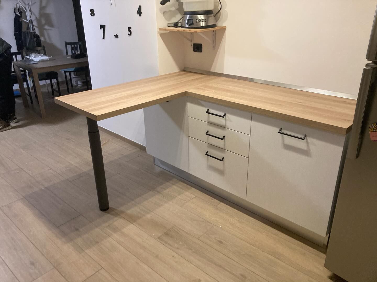Una cucina con piano di lavoro in legno e mobili bianchi