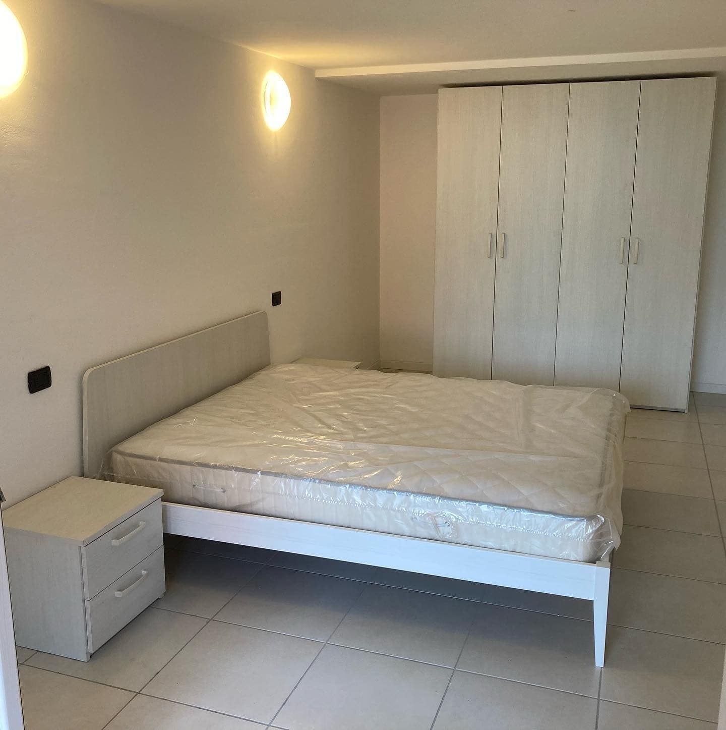 Una camera da letto con un letto grande e un comodino