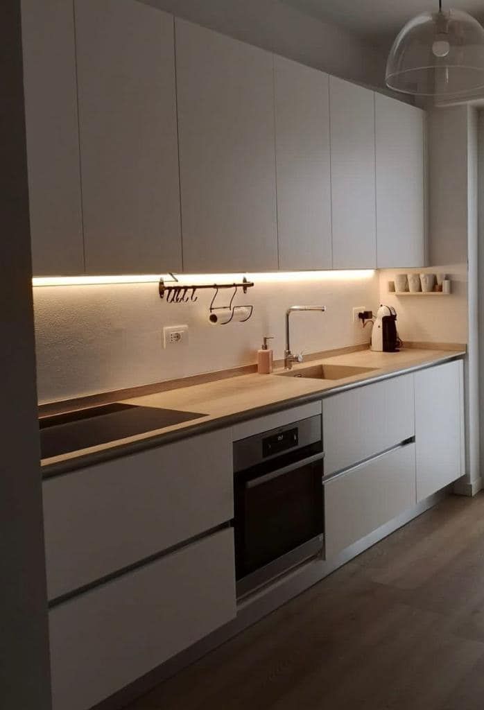 Una cucina con mobili bianchi ed elettrodomestici in acciaio inossidabile