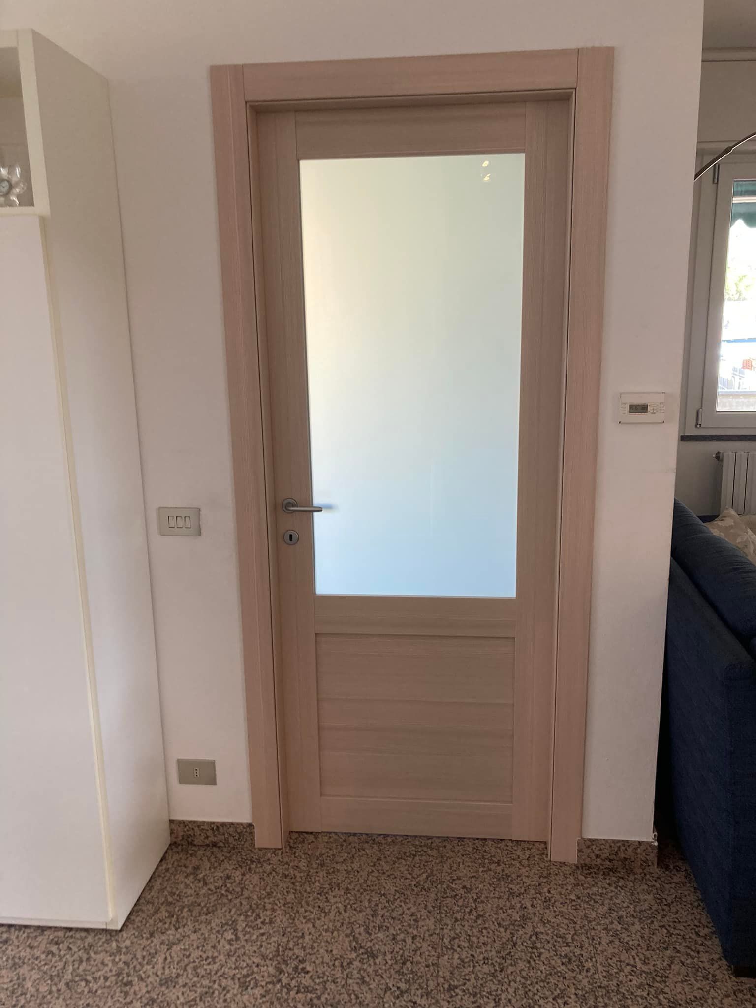 Una porta di legno con una finestra di vetro in un soggiorno.