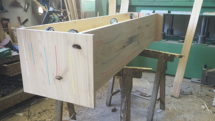 Una scatola di legno è appoggiata su un tavolo di legno in un'officina.