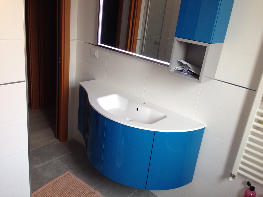 Un bagno con mobili blu e un lavandino bianco