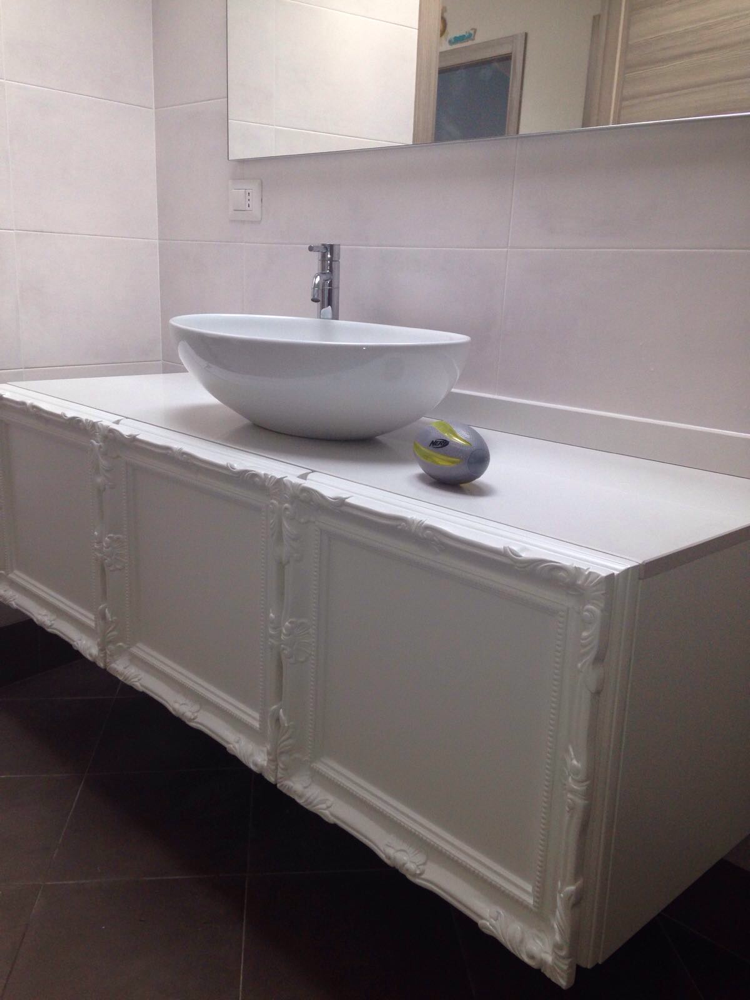 Un mobiletto per il bagno con lavandino e specchio