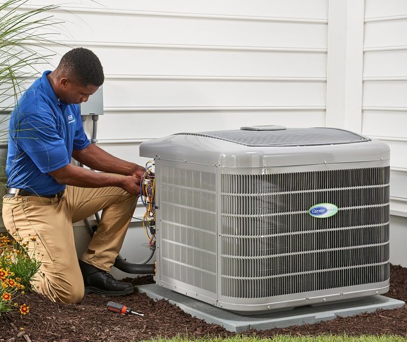HVAC technician repairs an outdoor air conditioning unit.