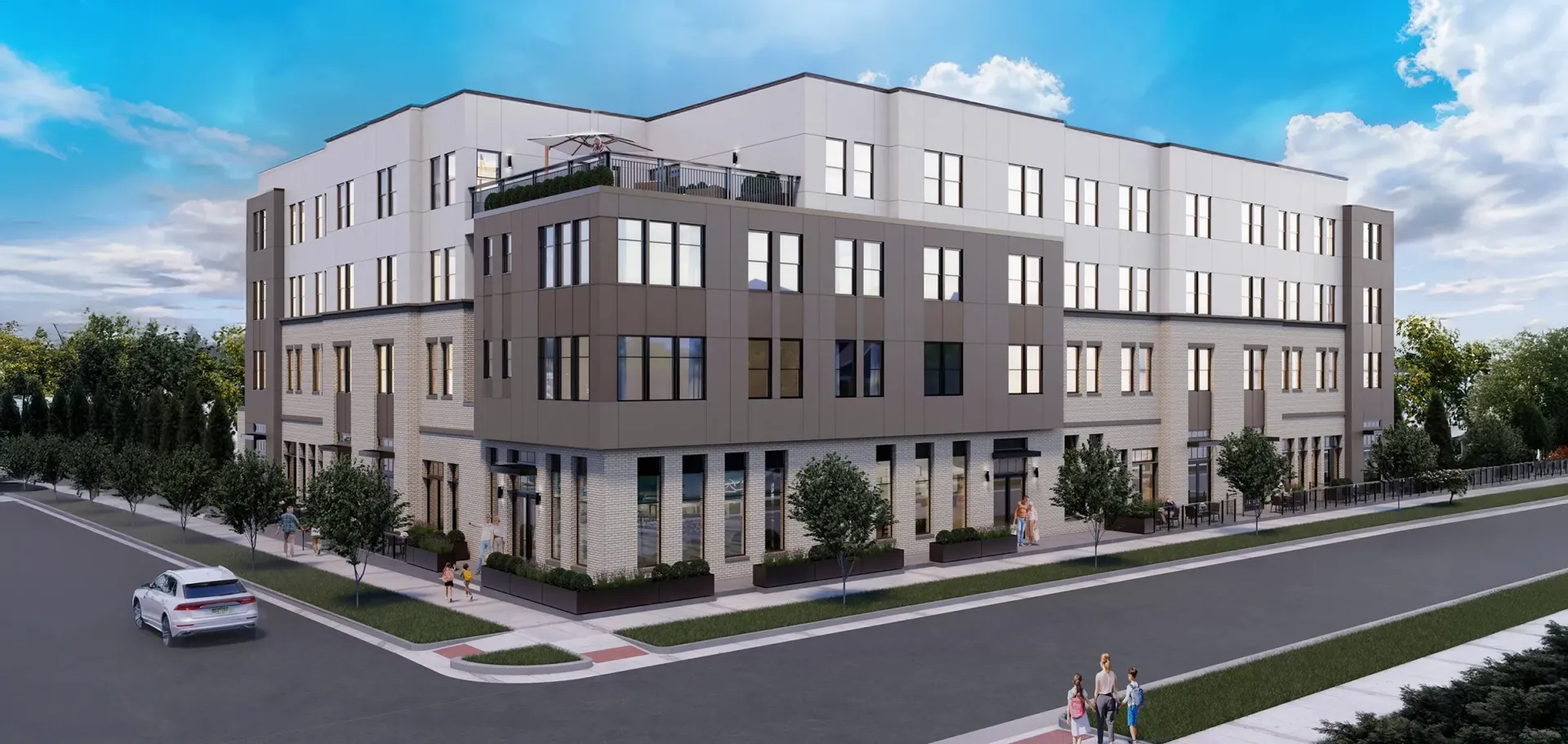 Modern gray three-story corner building with large windows on a street under a blue sky