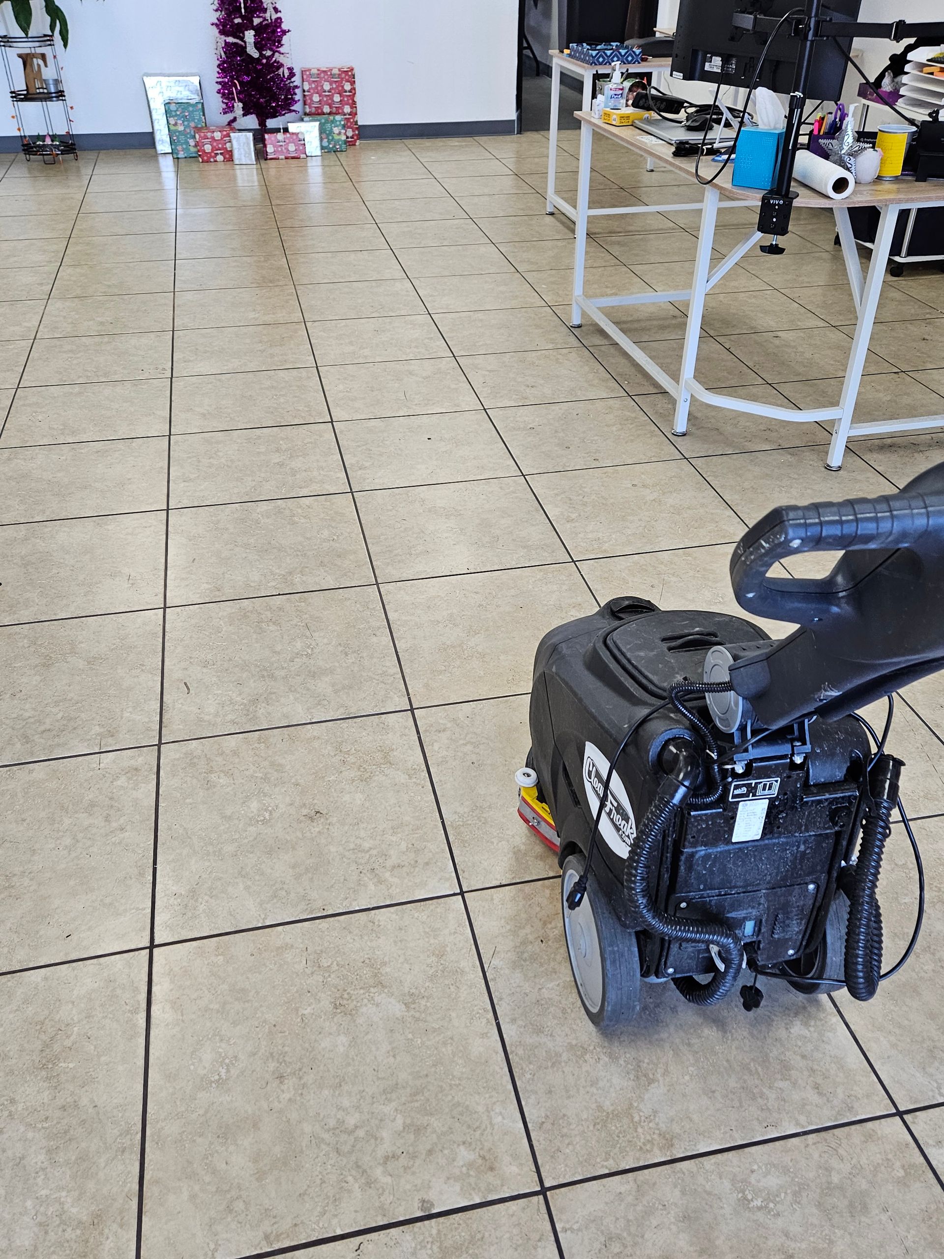 A lawn mower is sitting on a tiled floor in a room.