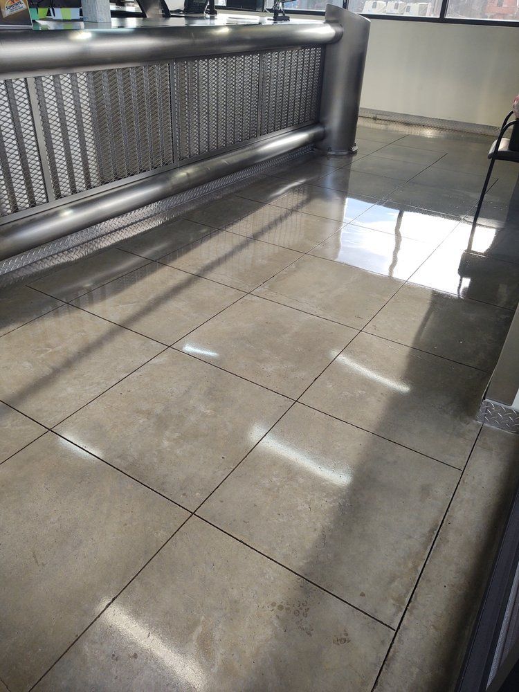 A close up of a tiled floor in a room with a metal railing.