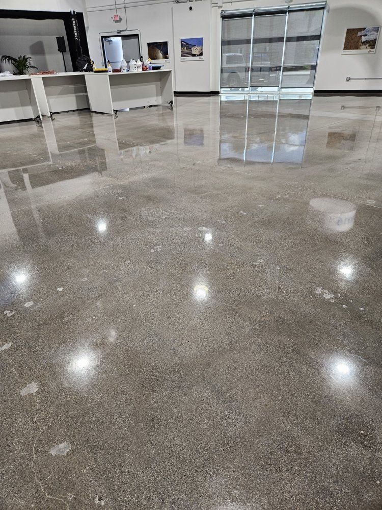 A shiny concrete floor in a room with a lot of lights on it.