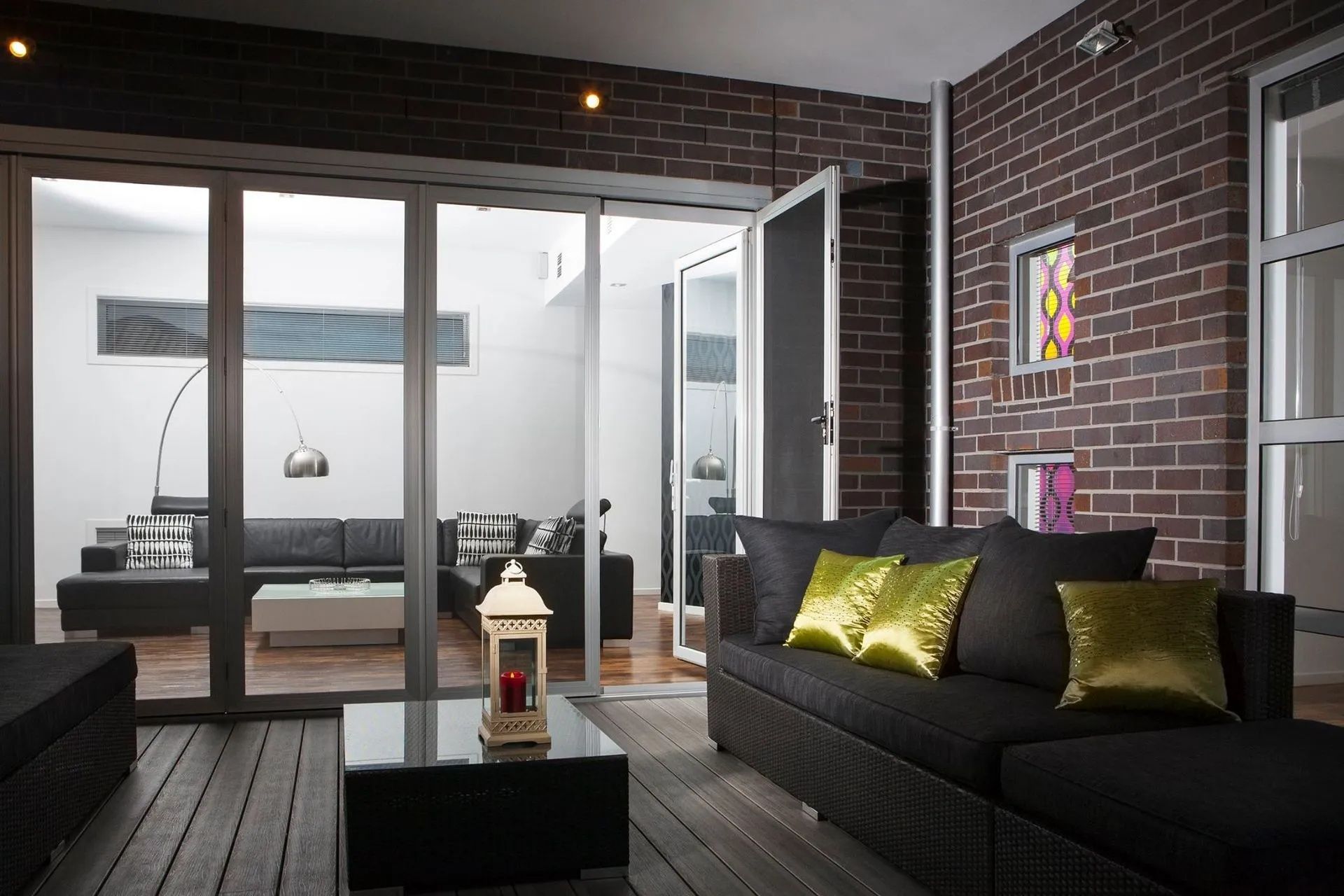 Living Room With Dark Brick Wall and Black Sofa — Keilbach Kitchens in Cairns, QLD