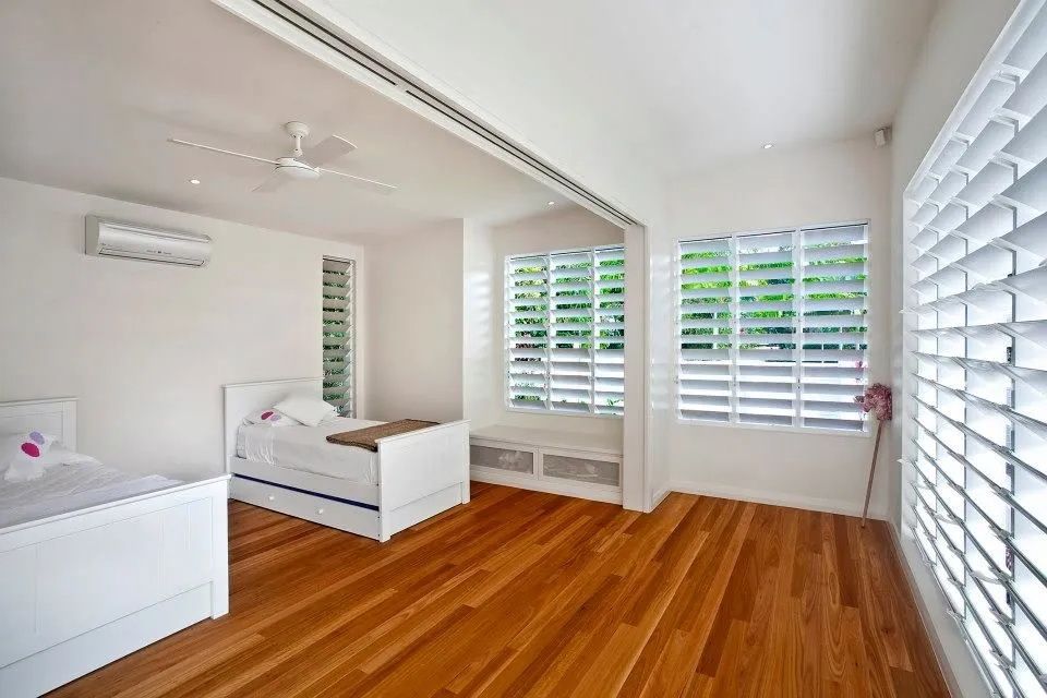 Bright Bedroom With White Walls, Wooden Floor, and Shutters — Keilbach Kitchens in Garradunga, QLD