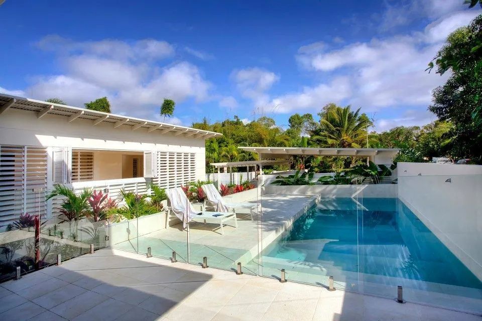 White House With Pool, Clear Blue Water and White Patio — Keilbach Kitchens in Tully, QLD