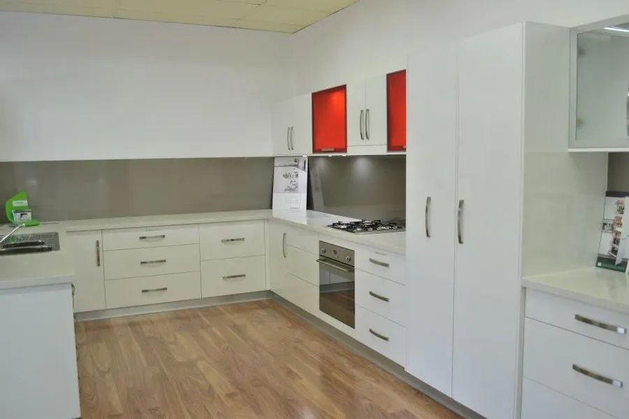White Kitchen Cabinets With Stainless Steel Backsplash — Keilbach Kitchens in Garradunga, QLD