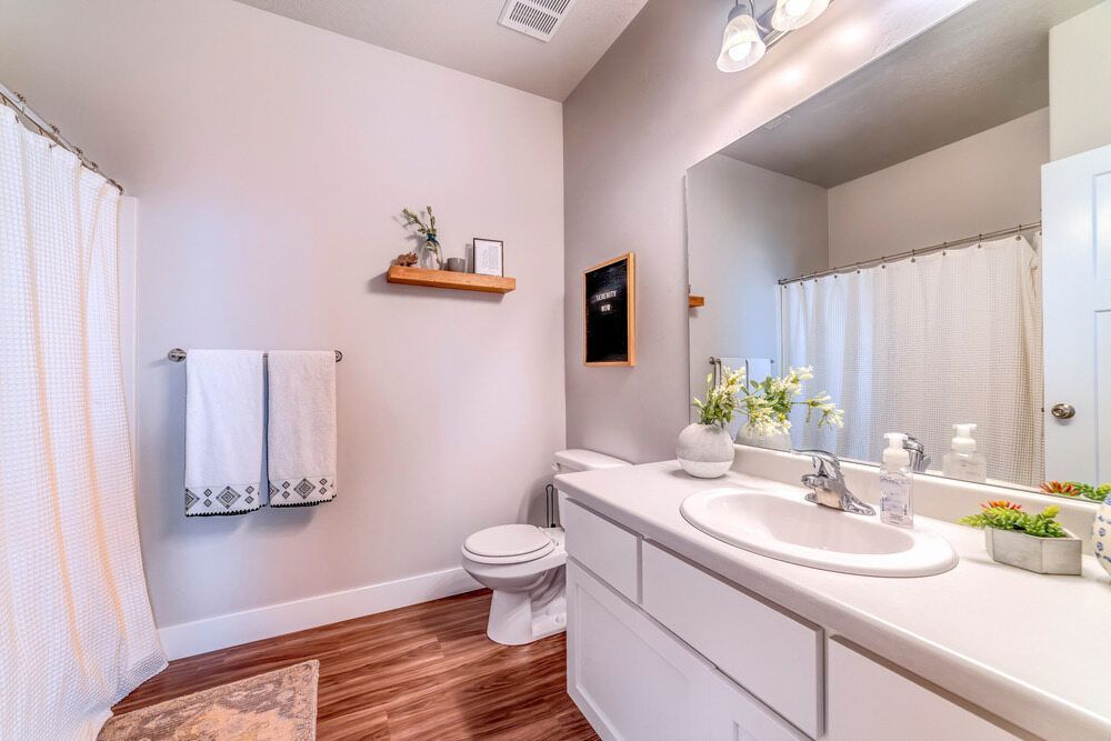 Bathroom With White Vanity, Toilet, and Shower Curtain — Keilbach Kitchens in Garradunga, QLD