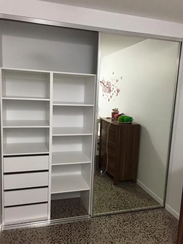 White Closet Shelving With Drawers Beside a Mirrored Sliding Door — Keilbach Kitchens in Garradunga, QLD