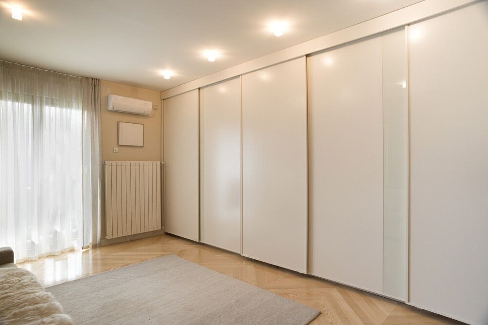 Bedroom With Large White Sliding Closet Doors — Keilbach Kitchens in Mission Beach, QLD