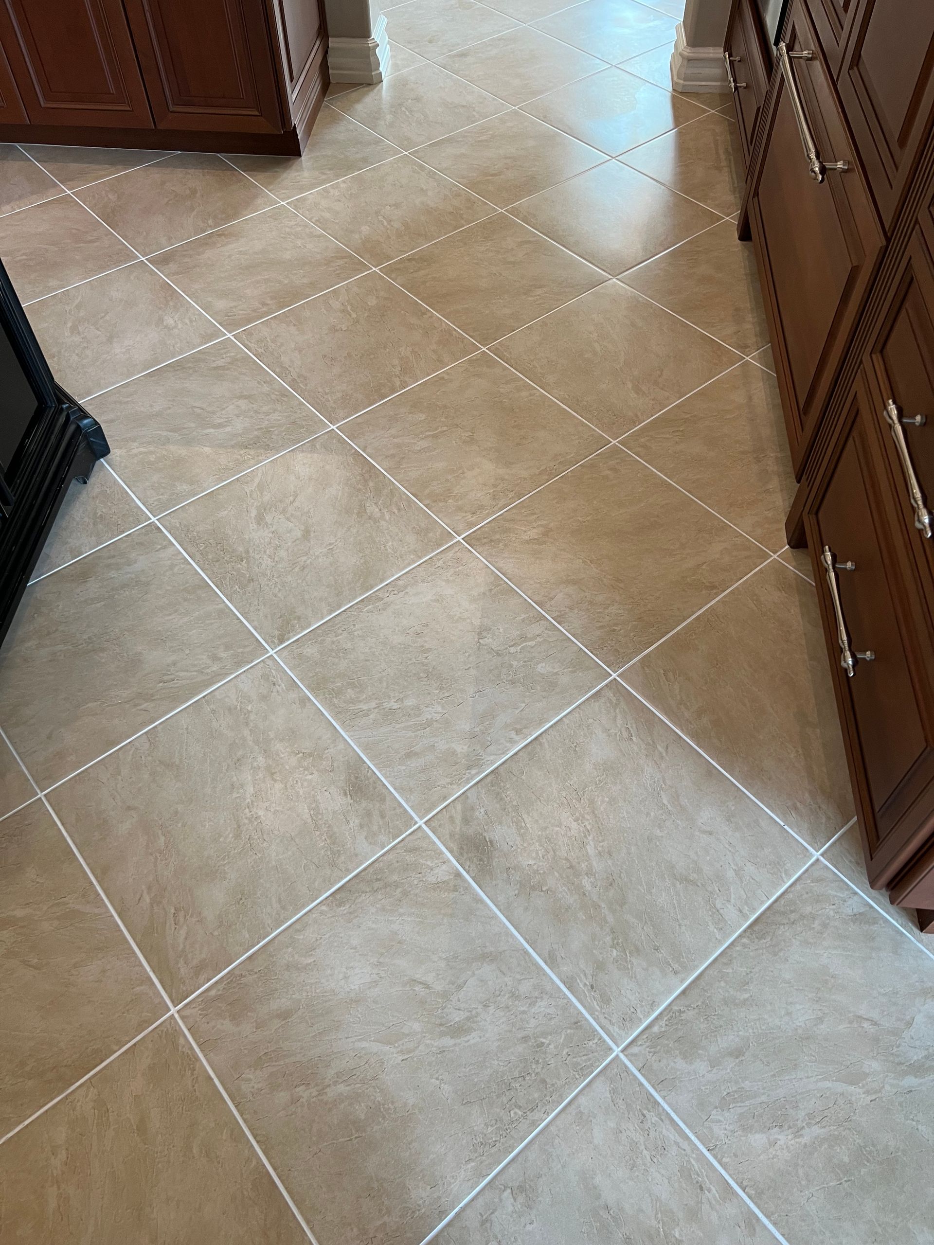 A kitchen with a tiled floor and wooden cabinets.