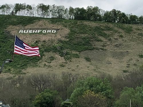 American flag waving near a hillside with