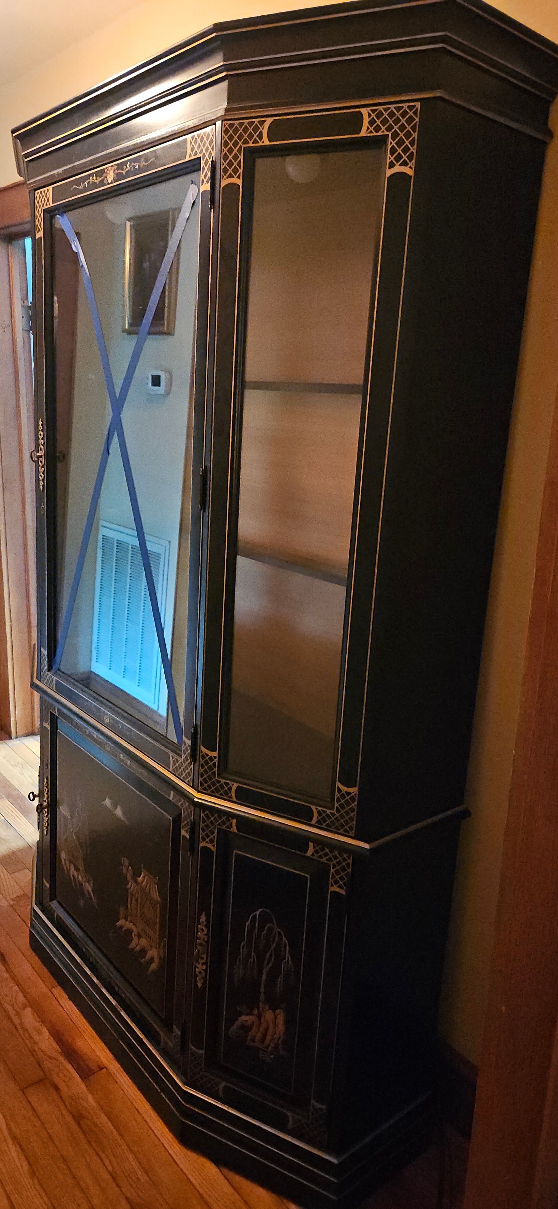 Dark wooden china cabinet with glass doors and decorative trim in a room