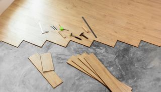 Wooden pieces and small hardware laid out on a tabletop, like parts for a craft or furniture project