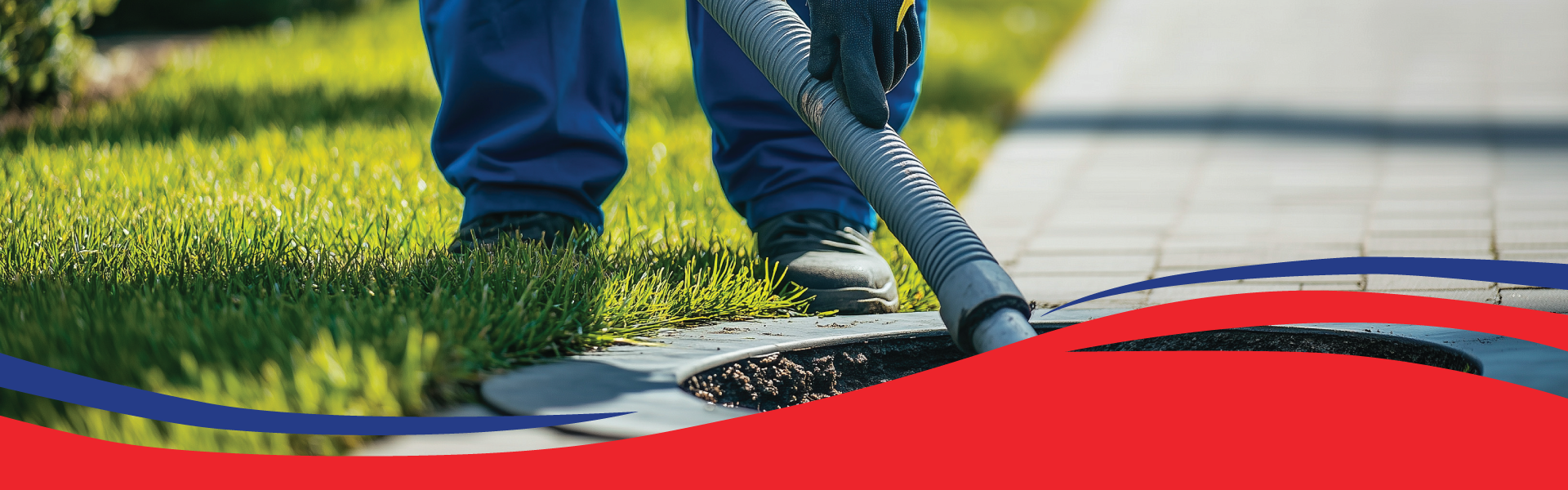 Commercial plumber using drain-cleaning equipment at an outdoor sewer access point.