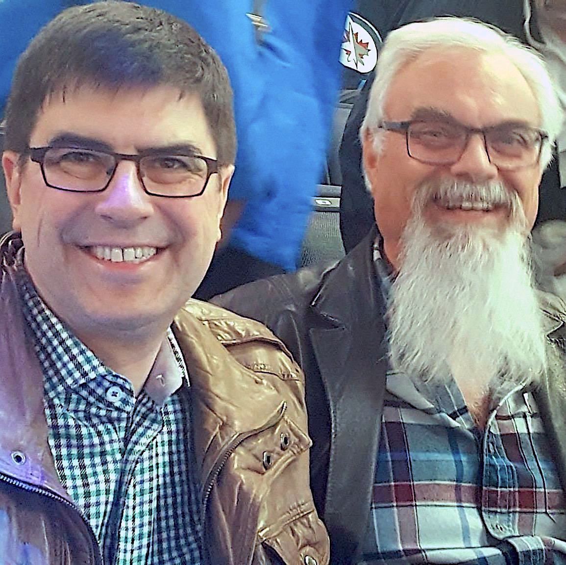 Close-up of David and Randy from Bird River Band, sitting side by side and smiling, invitingly posing.