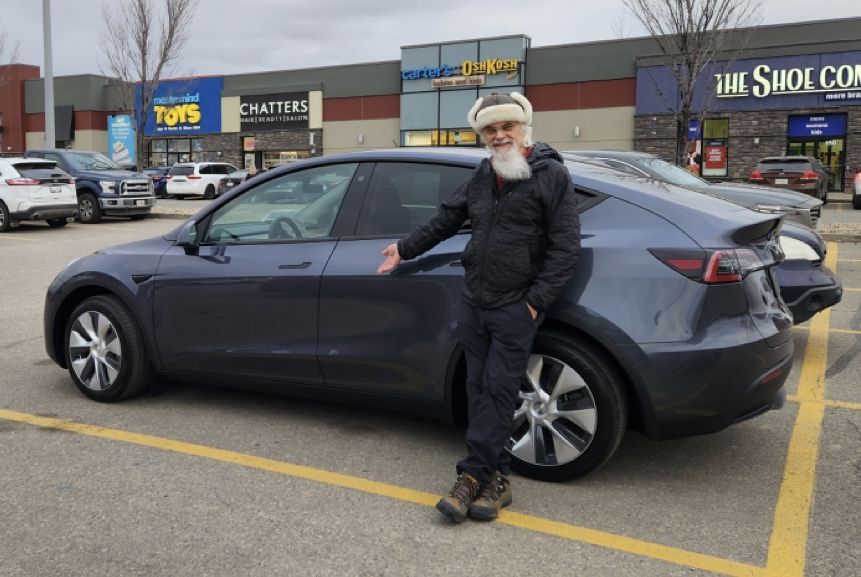 Randy standing beside his band's new 'tour bus,' a Tesla, during a tour through the South where he played several music gigs.