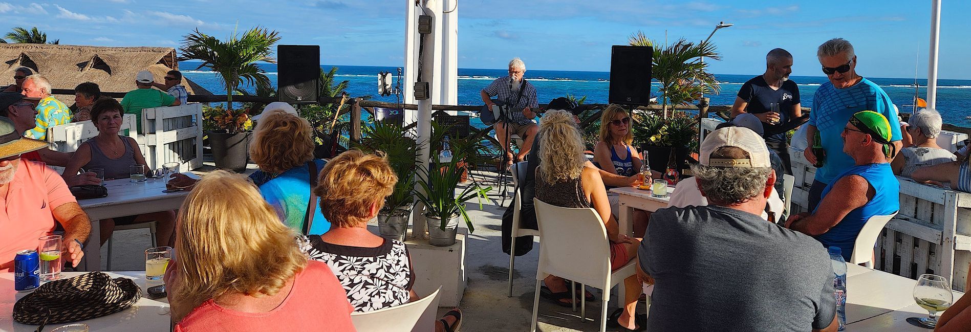 Randy playing acoustic guitar and singing to the crowd, on the rooftop, for an epic vacation gig.