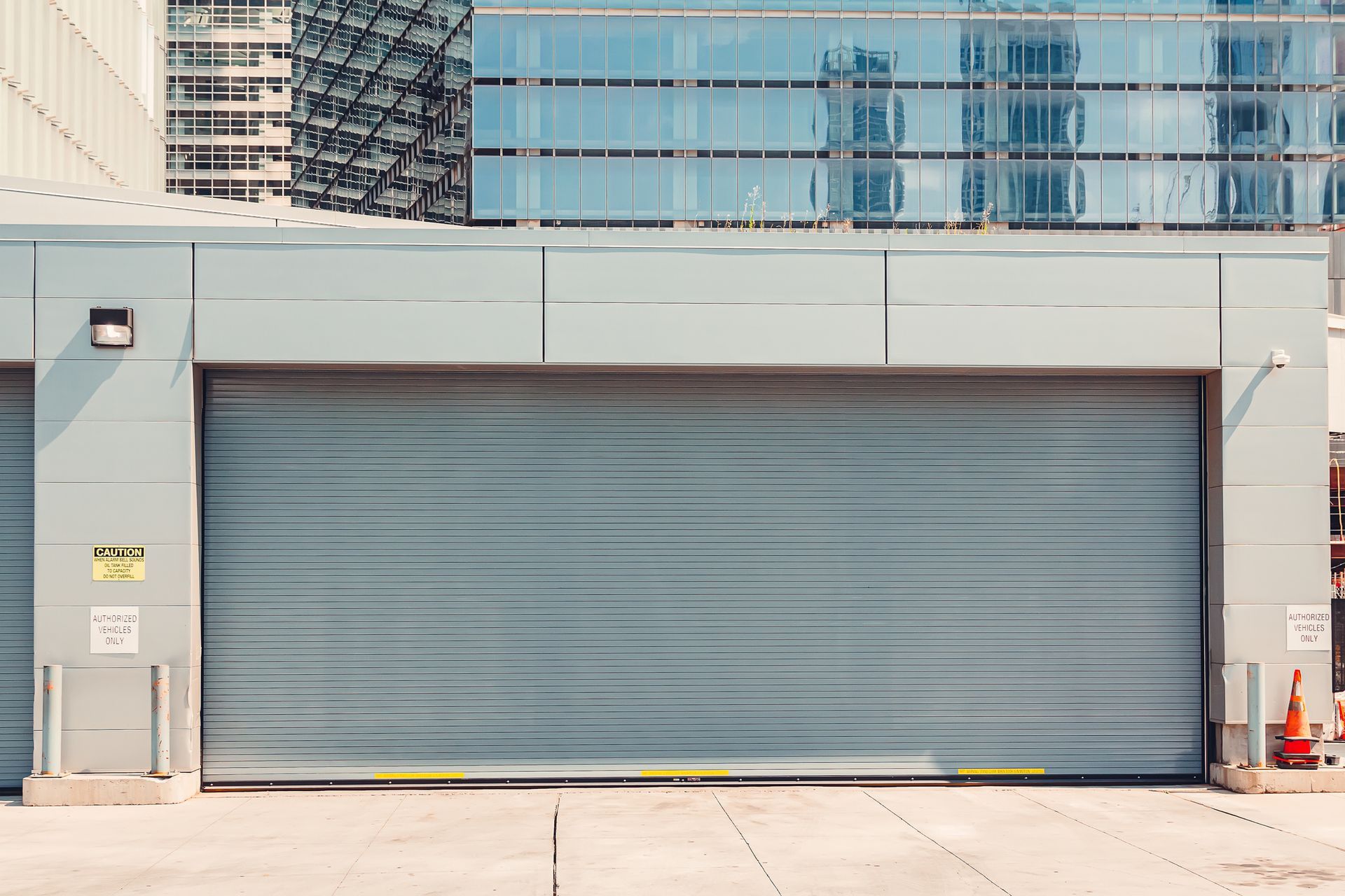 A large gray garage door is open in front of a large building.