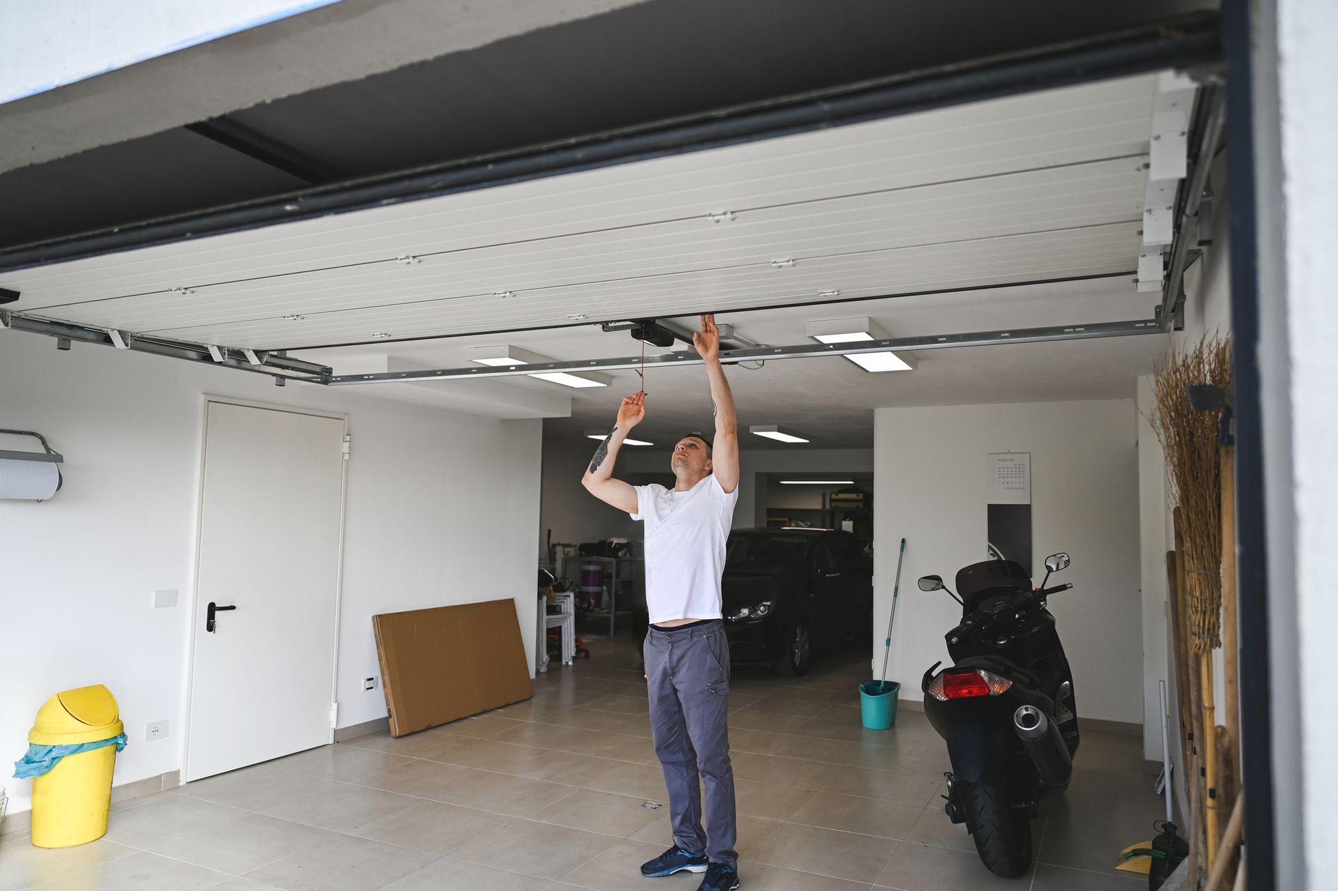 A man is standing in a garage looking up at the ceiling.