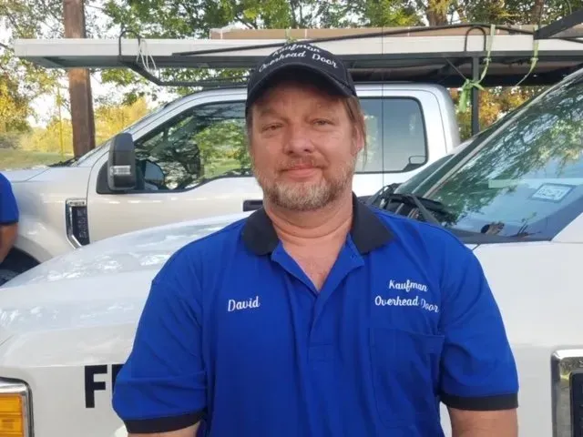 A man wearing a blue shirt with the name david on it