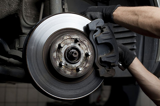 Hands Wearing Black Gloves Working On A Car Brake Disc And Caliper — KND Autos in Berrimah, NT