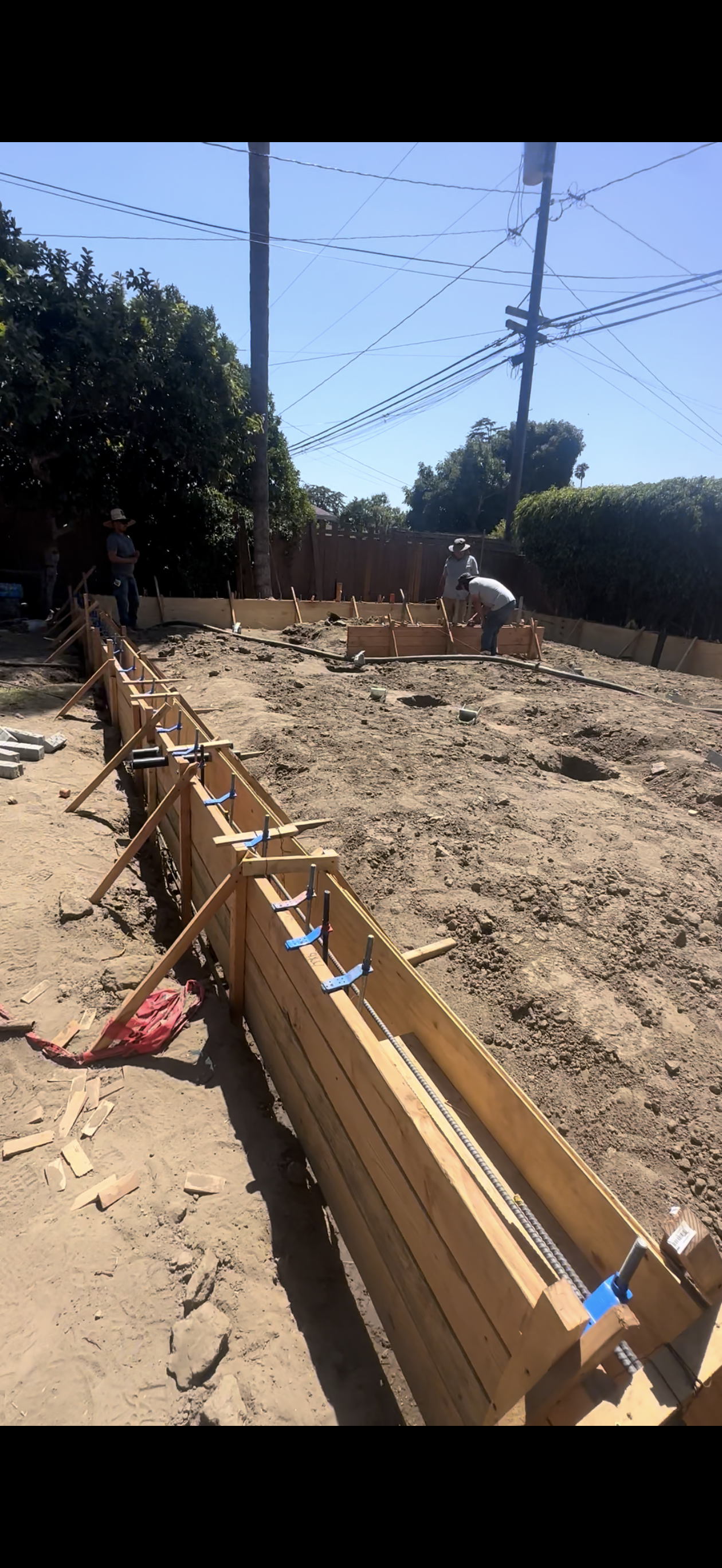 Construction site with wooden forms for concrete along the perimeter.
