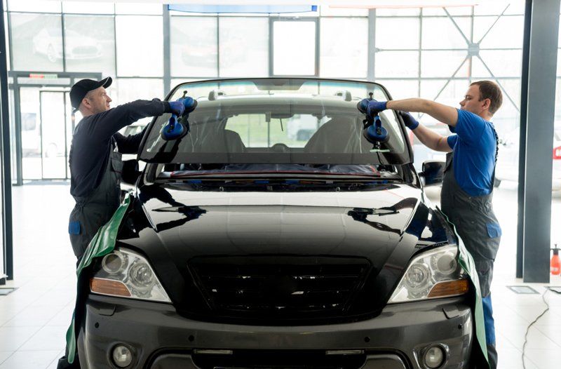 Two Workers Replacing Windscreen — A1 Windscreens in Taminda, NSW