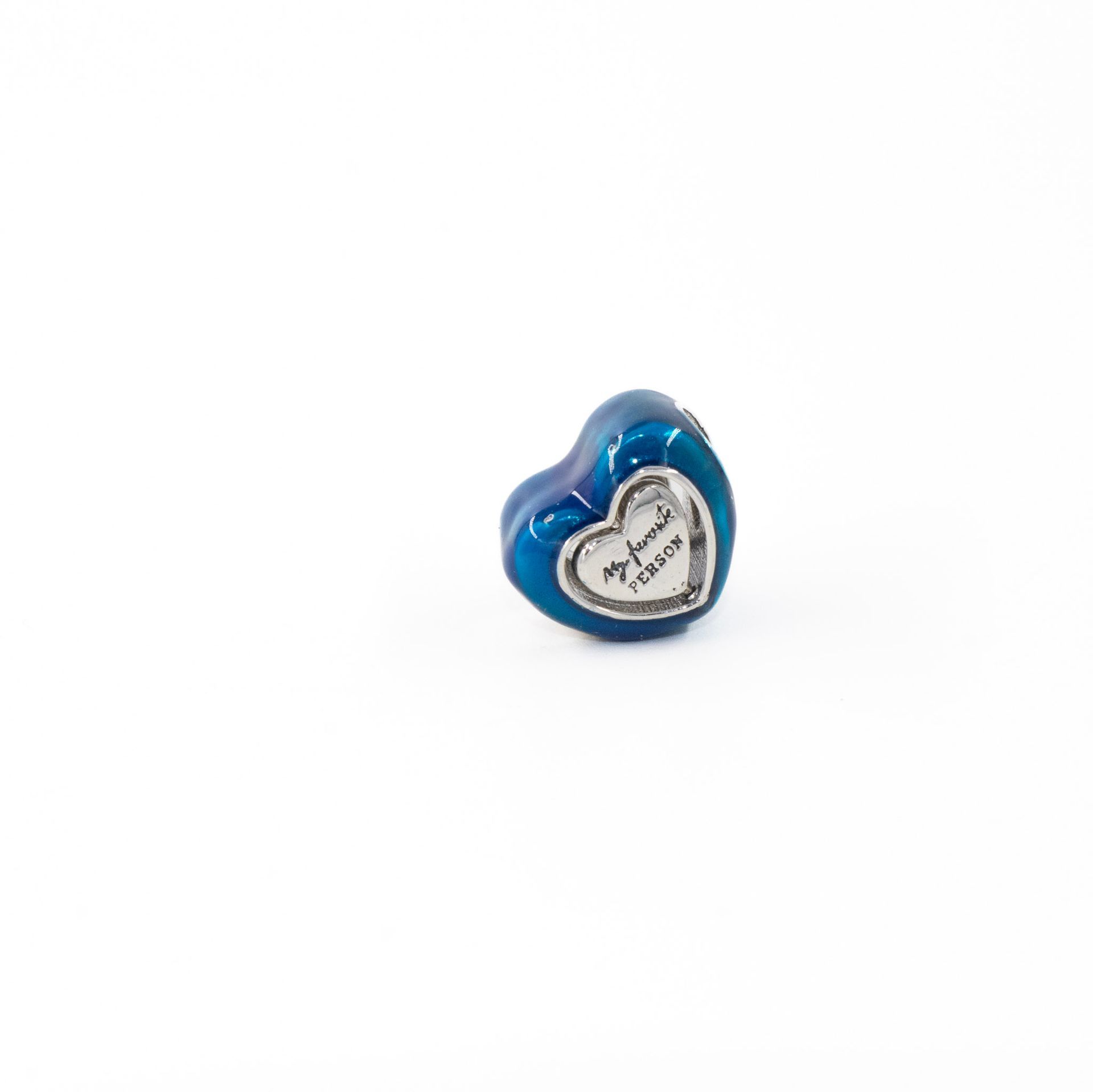 Colgante de cuentas azules en forma de corazón con detalles plateados sobre fondo blanco.