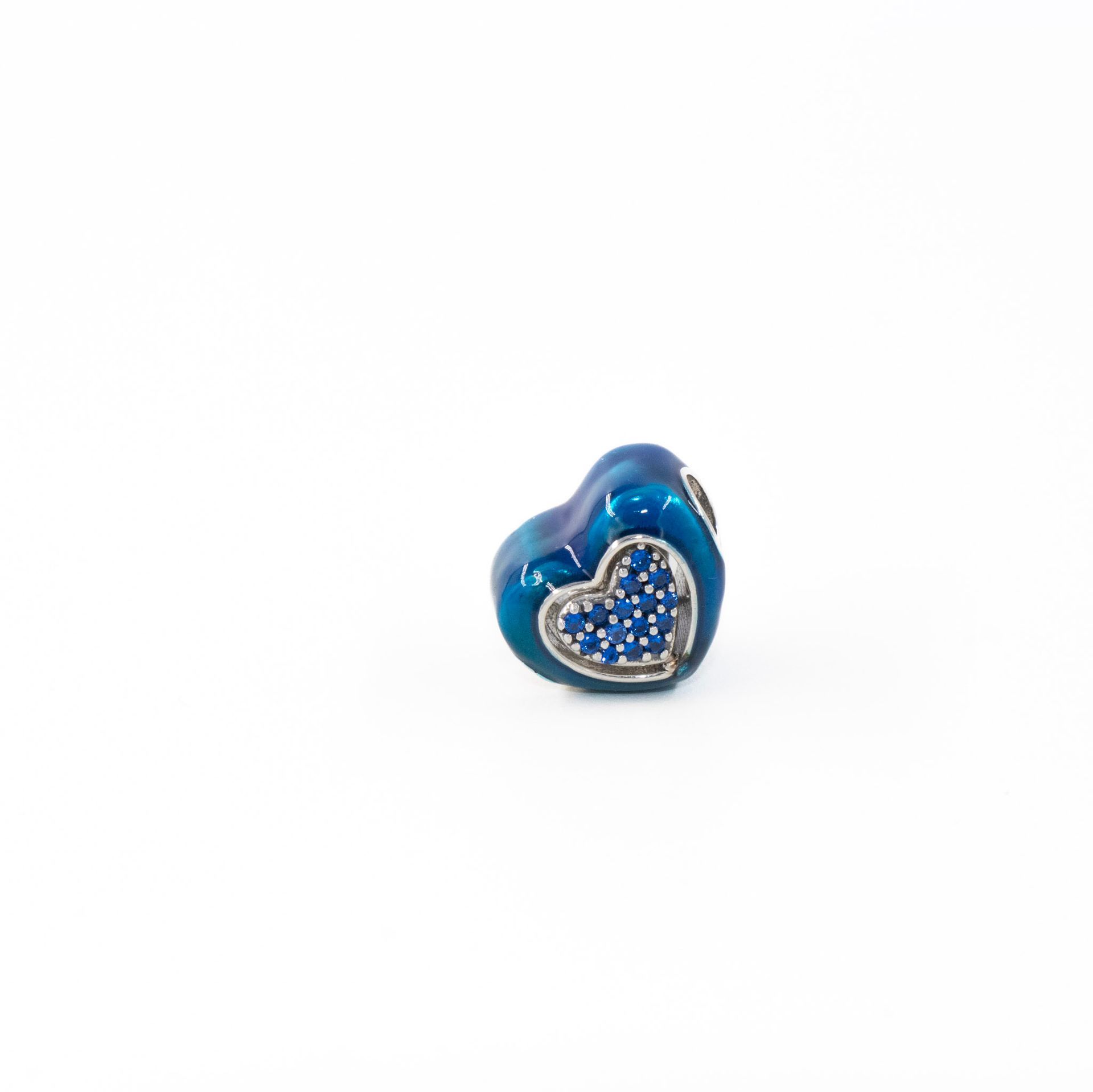 Colgante de cuentas azules en forma de corazón con detalles plateados sobre fondo blanco.