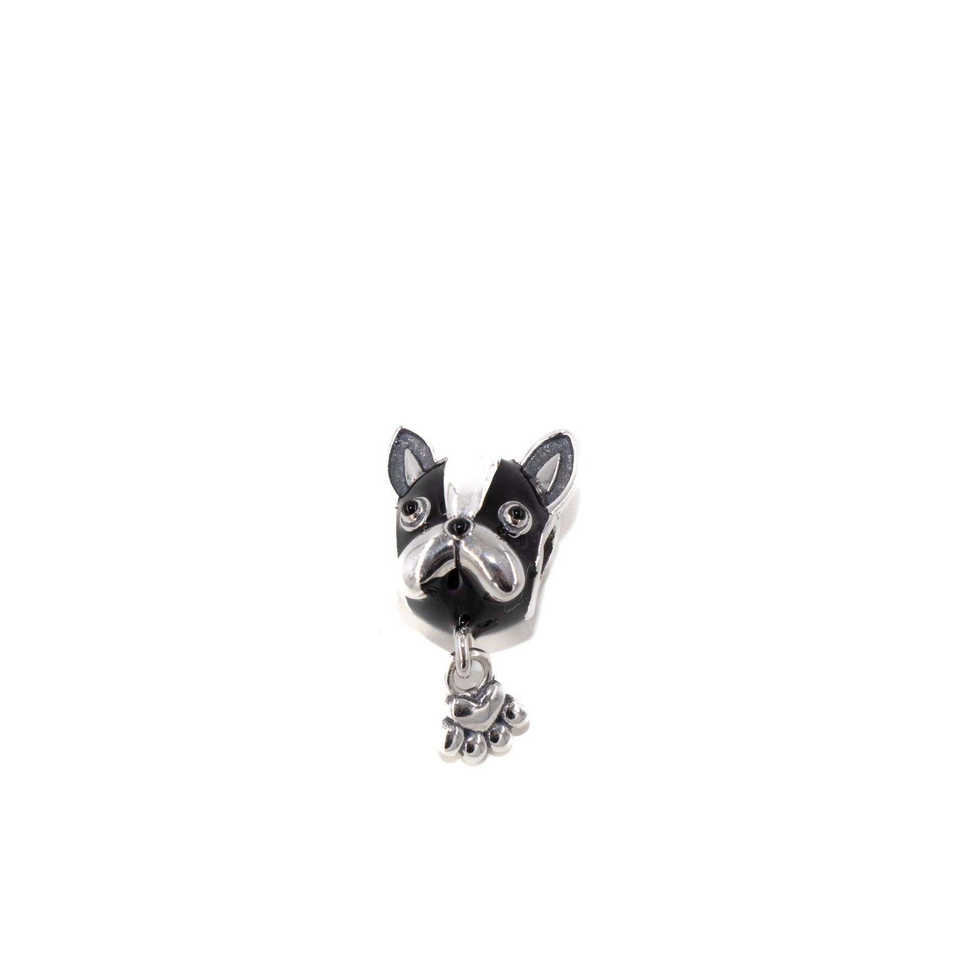 Pequeño colgante negro con forma de perro con detalles plateados sobre fondo blanco.