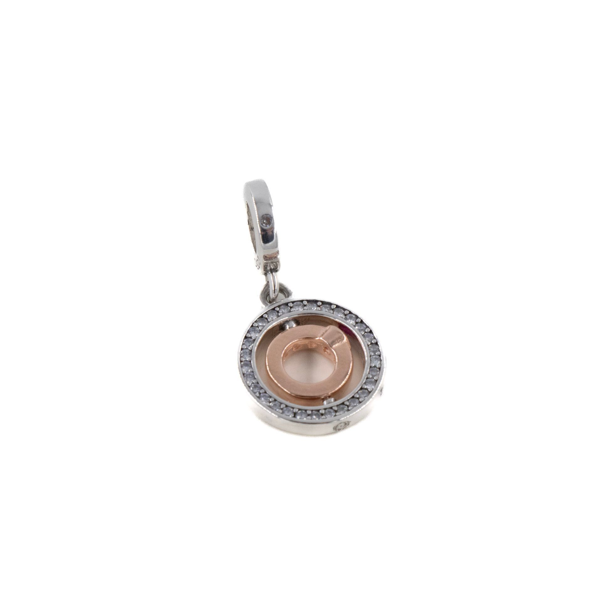 Pequeño colgante de plata con centro de oro rosa y piedras transparentes alrededor del borde.