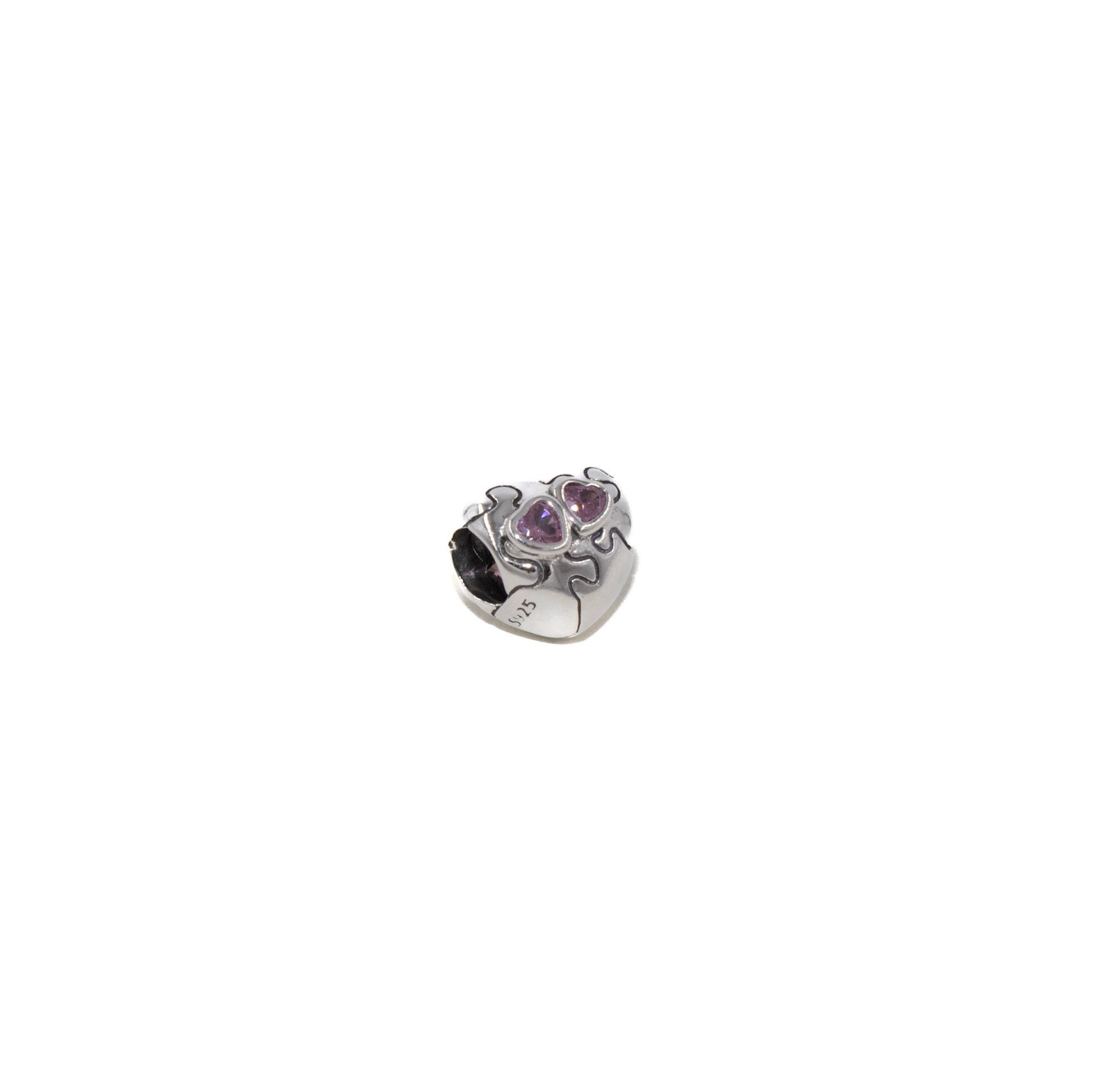 Anillo pequeño de plata con piedras preciosas moradas sobre fondo blanco.