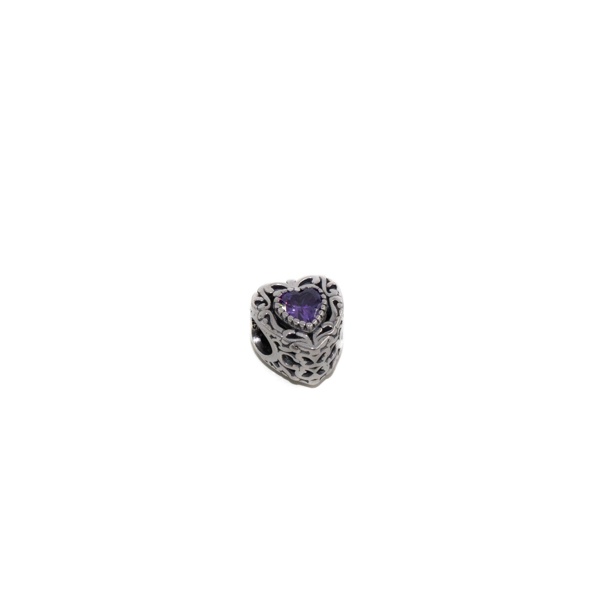 Anillo de plata con forma de corazón y una piedra preciosa morada en el centro.
